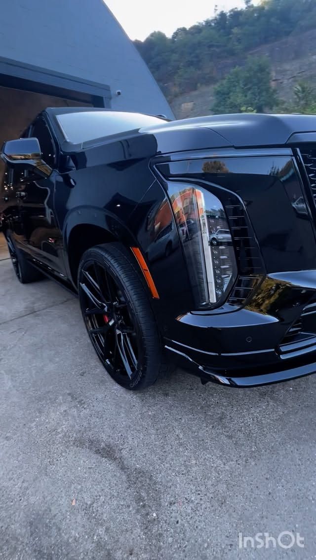 Black SUV with black rims parked outside.