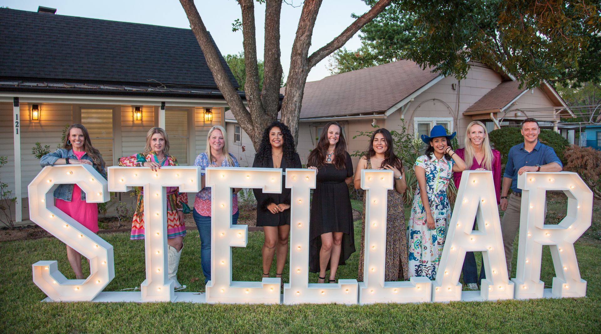 A group of people standing in front of a sign that says Stellar.