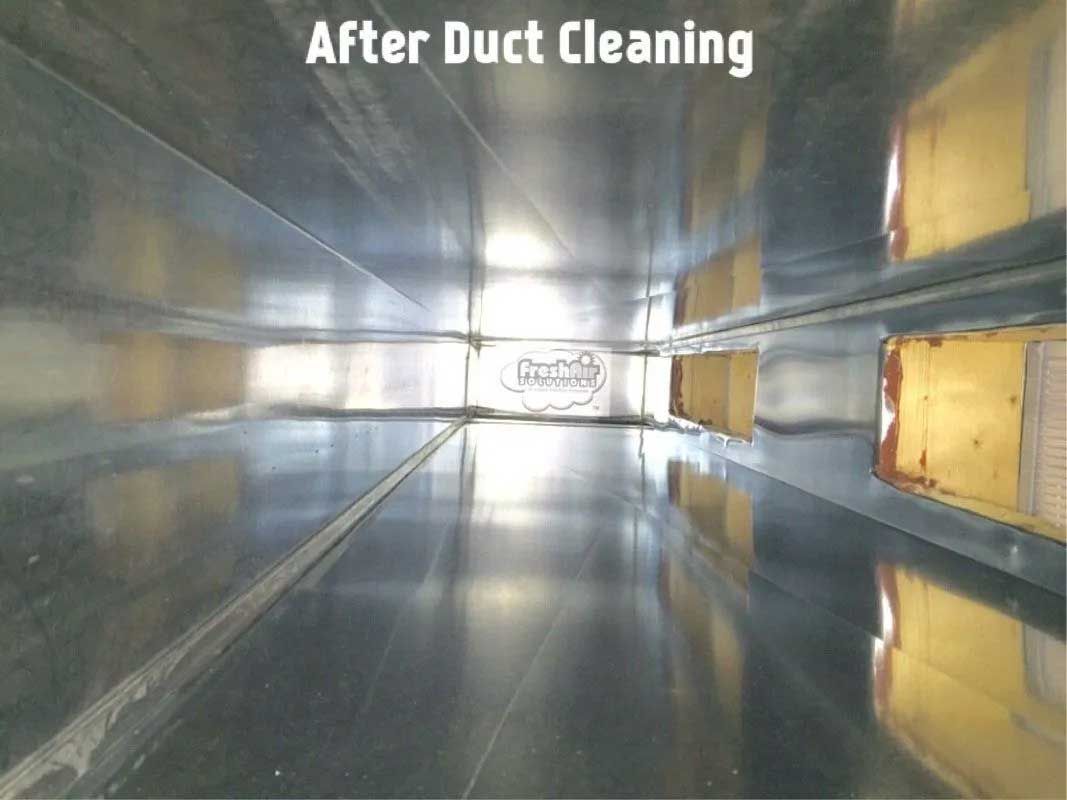 Clean, silver-colored HVAC duct interior after cleaning. View down a rectangular duct with vents along the sides.