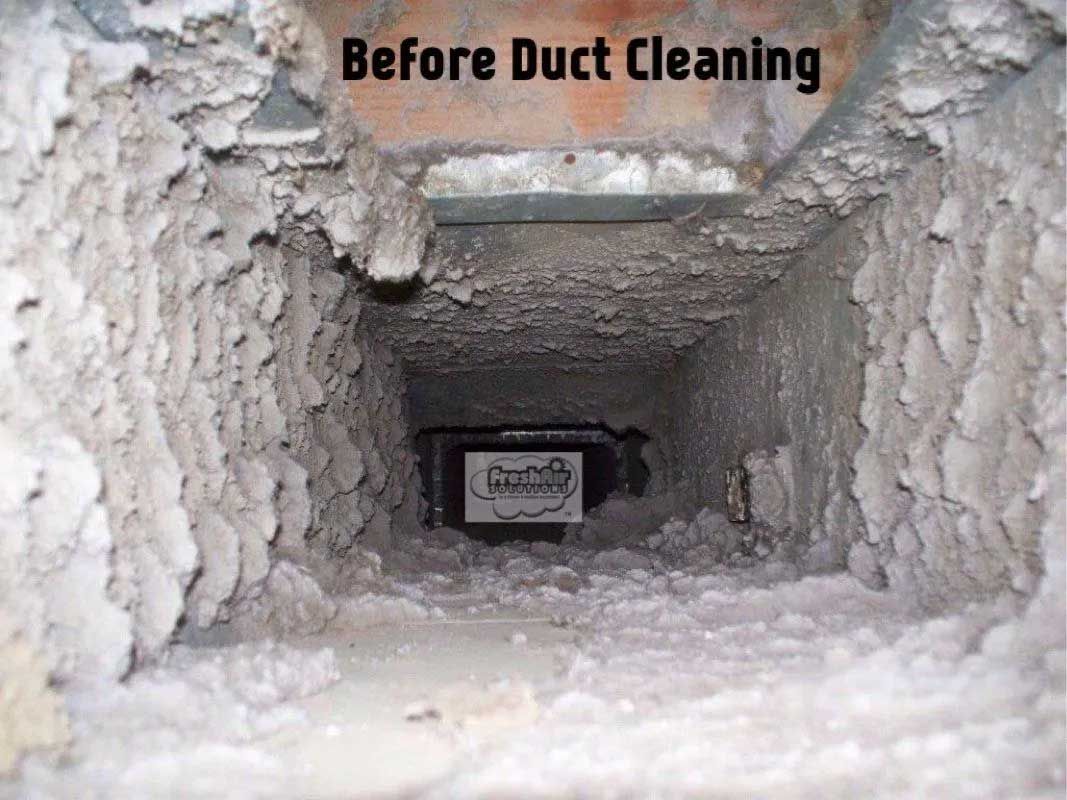 Dirty air duct interior before cleaning, filled with thick layers of dust and debris.