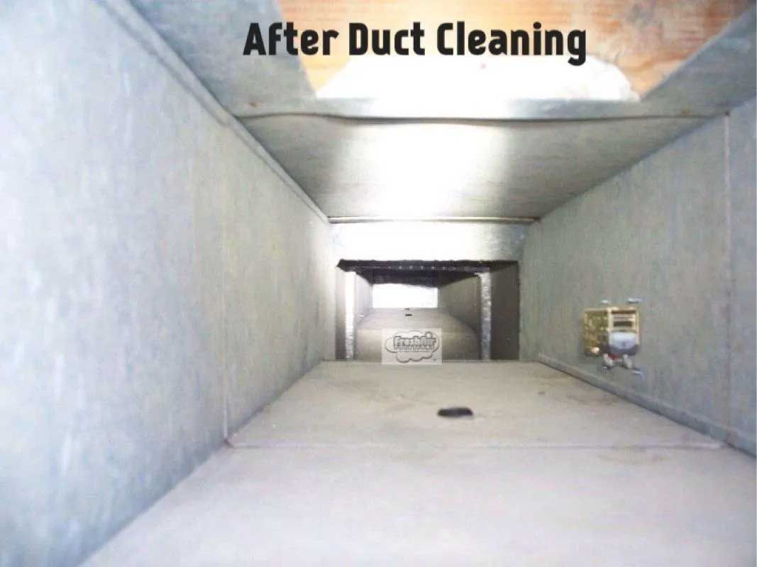 Clean, rectangular air duct interior after cleaning, gray walls and floor, lit from above.