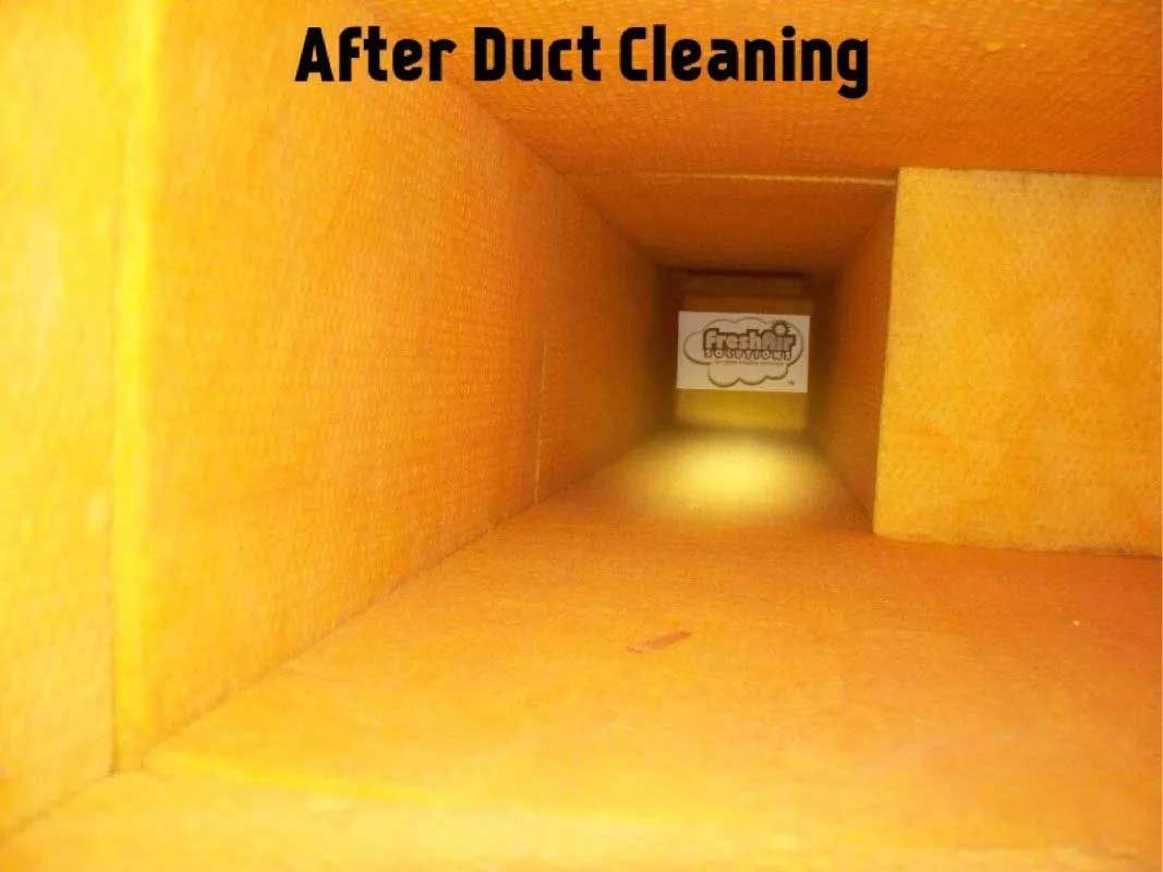 A clean air duct interior with yellow insulation after duct cleaning.