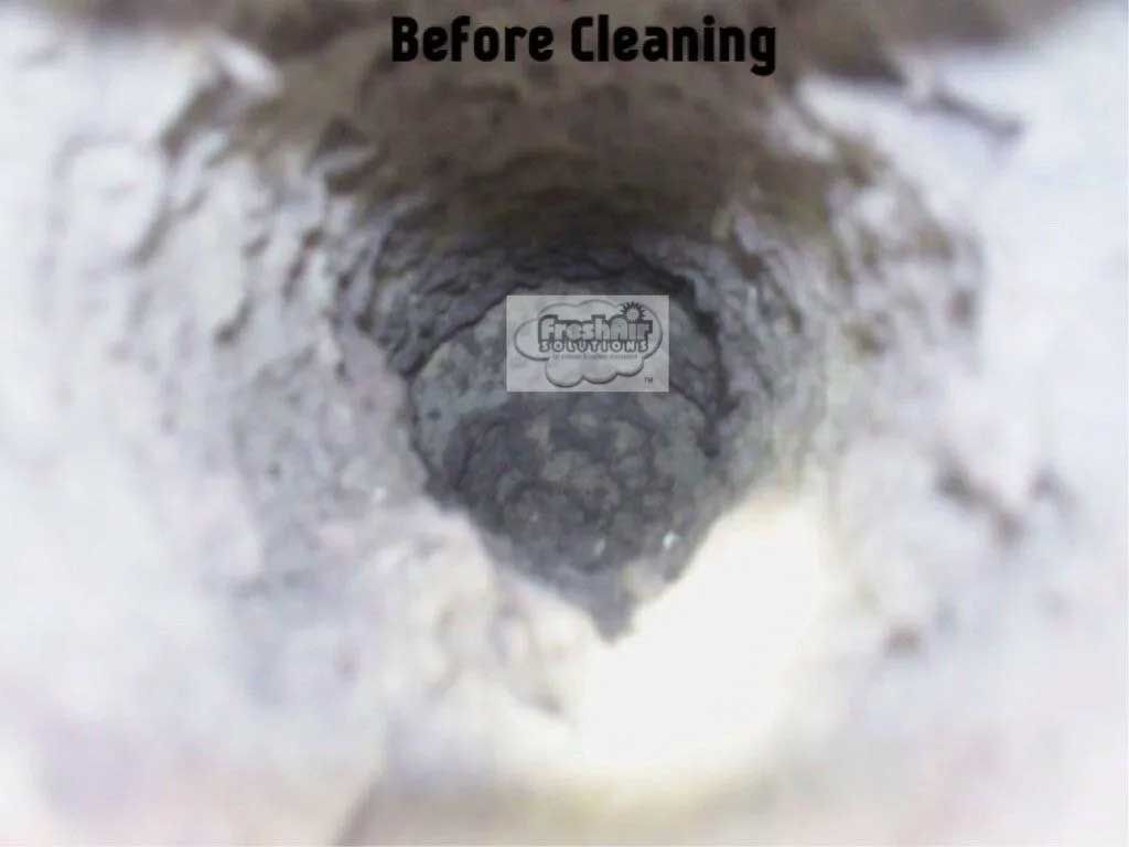 Close-up view of a dirty opening, dark inside. Text 