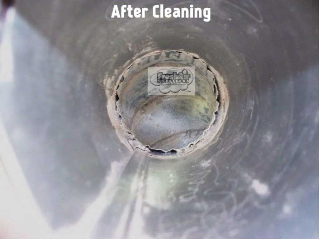 Inside of a duct after cleaning, showing a circular opening and some residue.