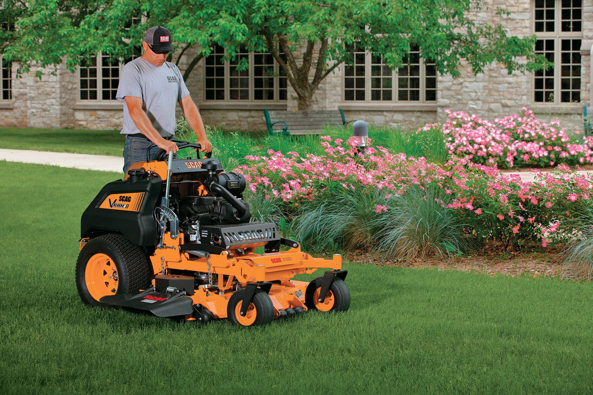 A man is riding a yellow and black lawn mower on a lush green lawn.