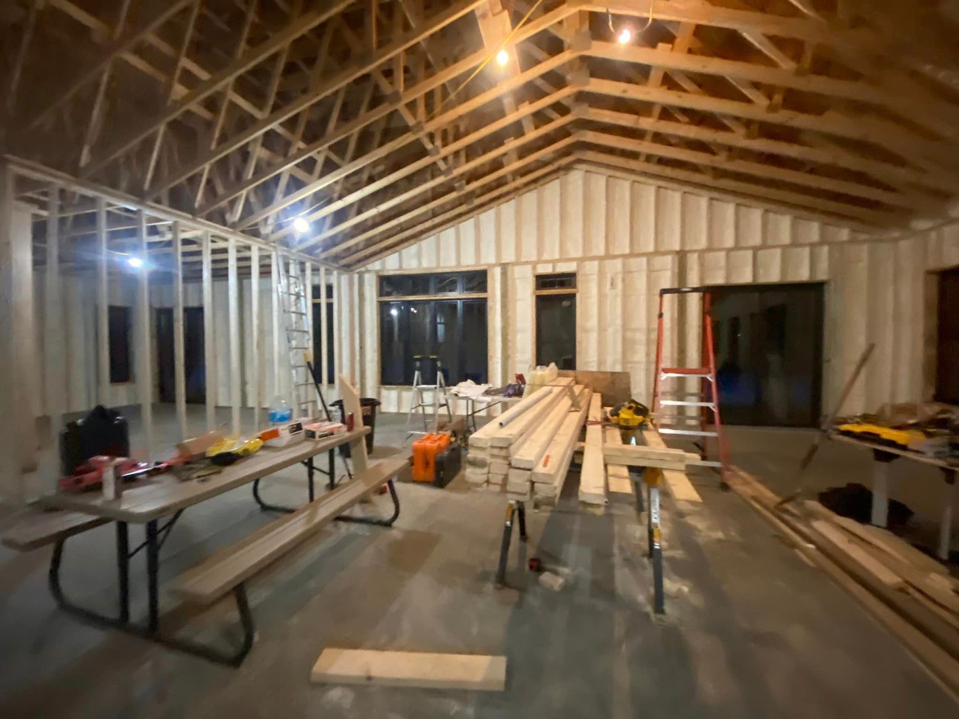 a room under construction with a picnic table and benches