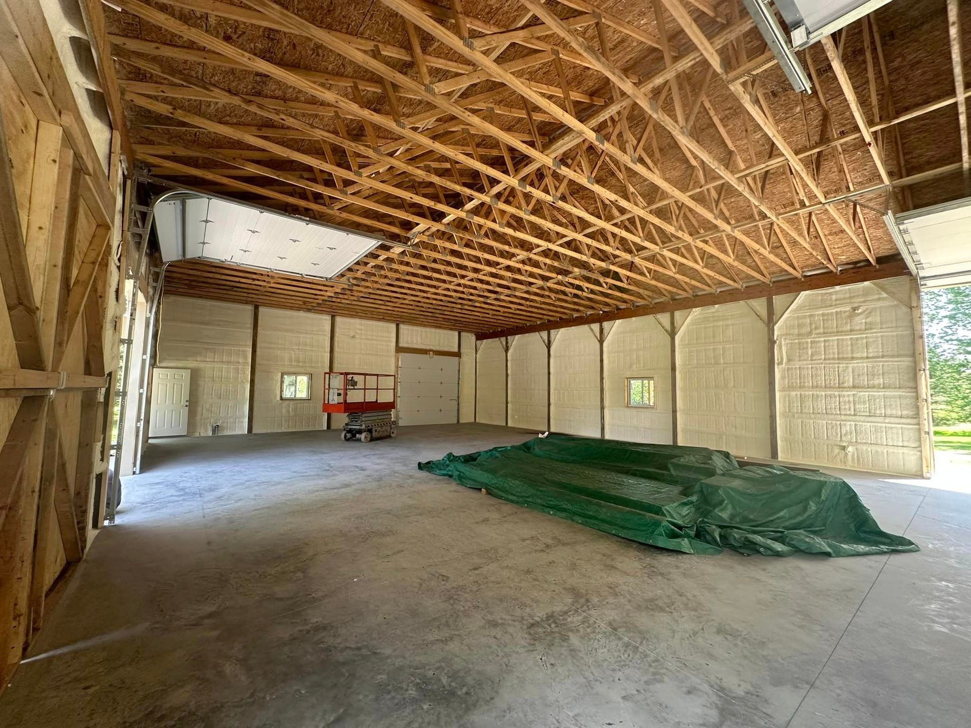 a large empty building with a green tarp on the floor