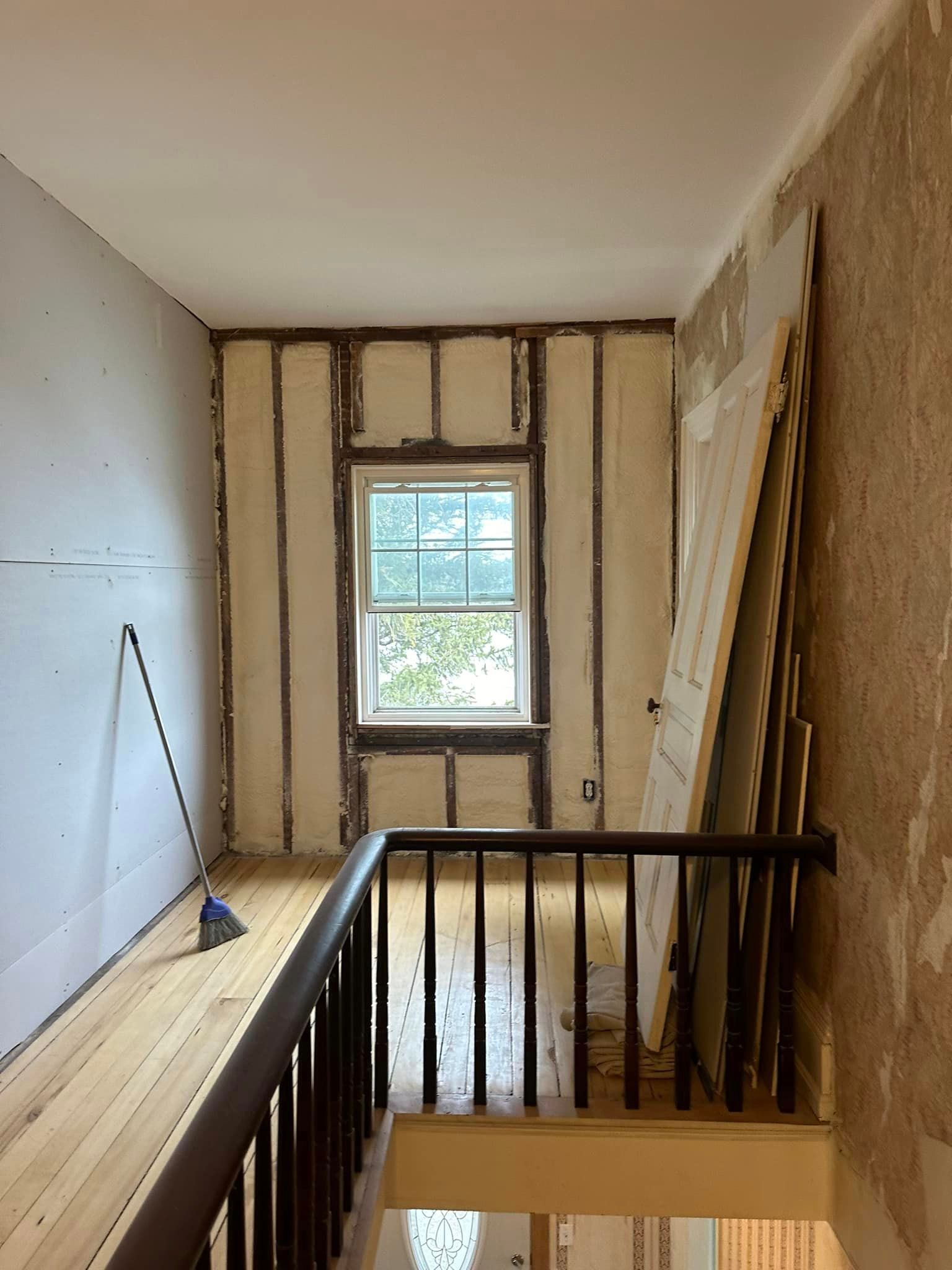 a staircase leading up to a room with a window and a railing