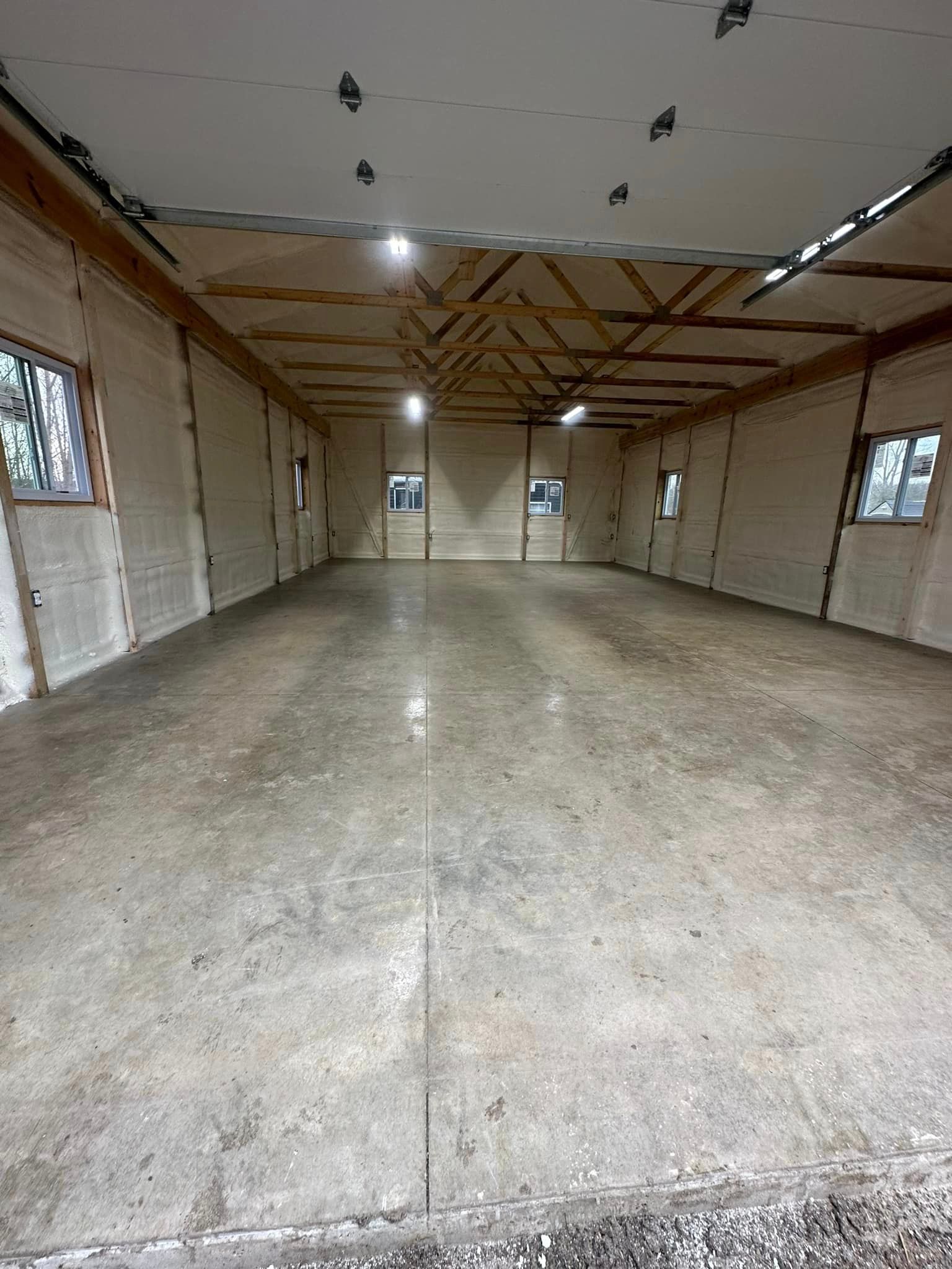 a large empty garage with a concrete floor and a garage door