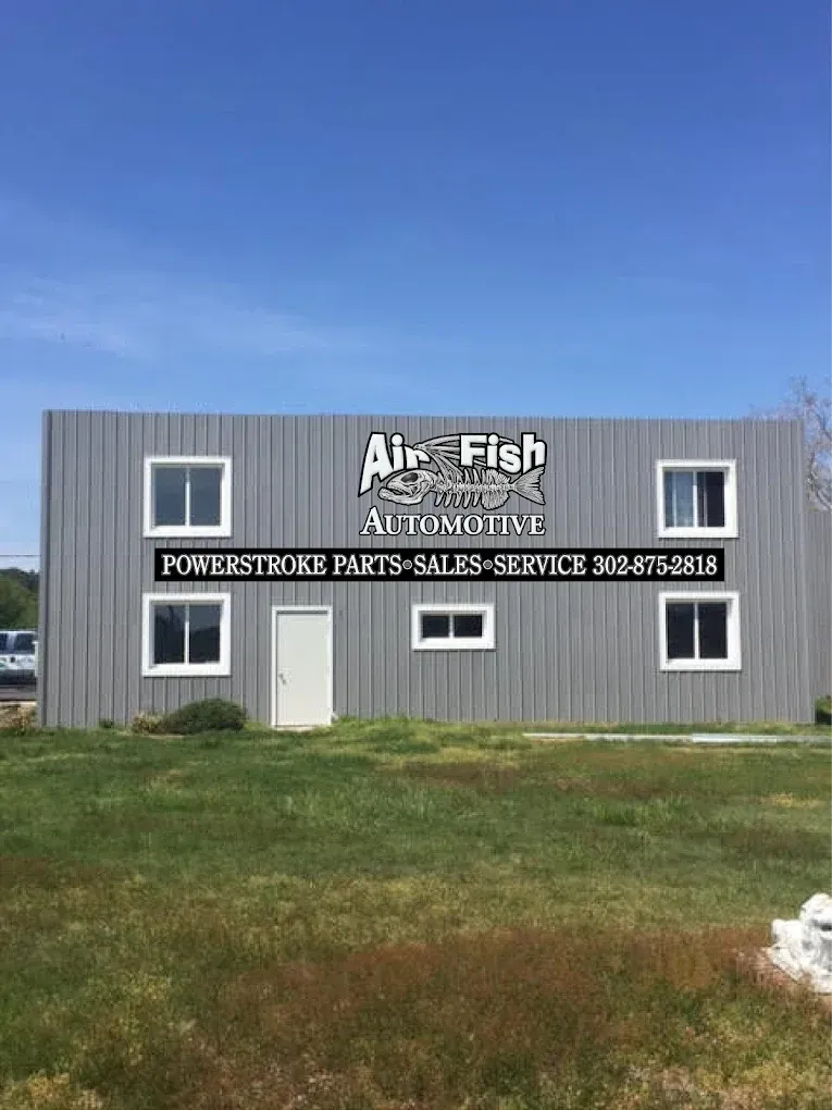 Air-Fish Auto, a gray building with windows, a door, and signage for Powerstroke parts, sales, and service.