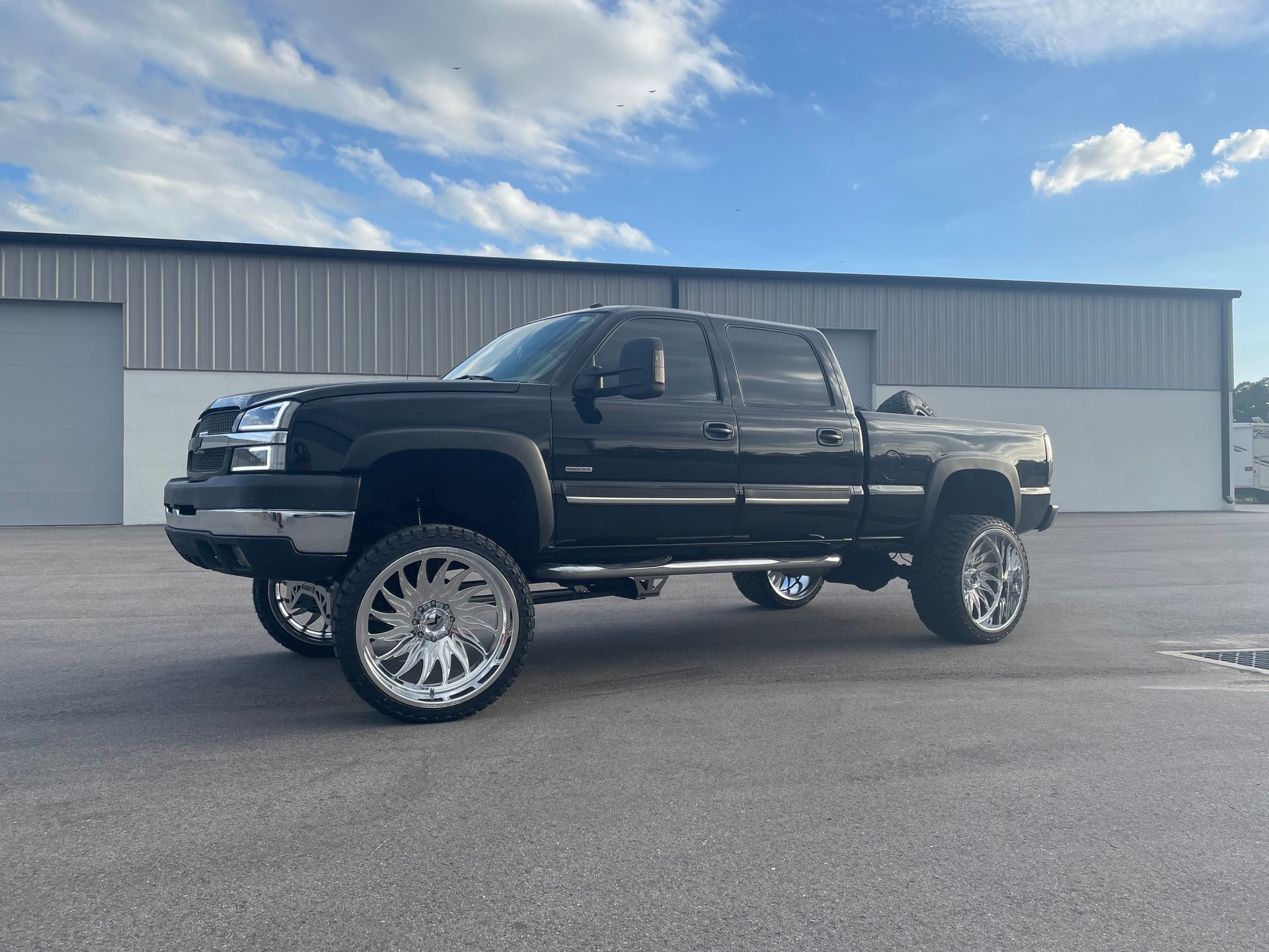 A black truck is parked in front of a building.