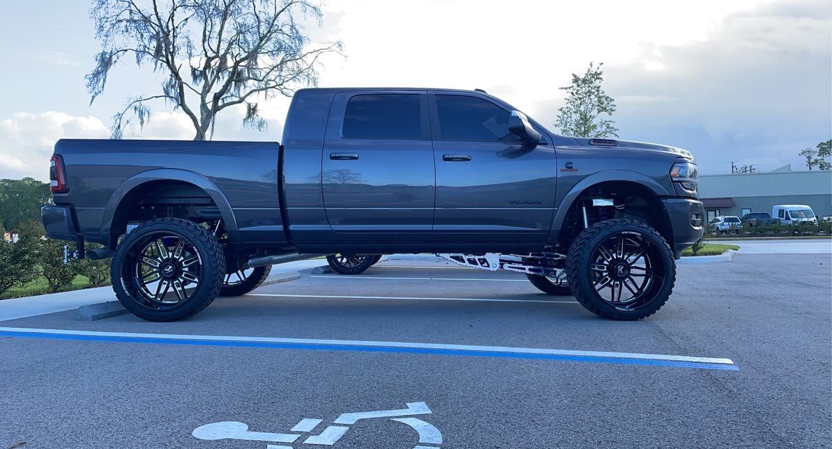 A gray truck is parked in a handicapped parking spot.