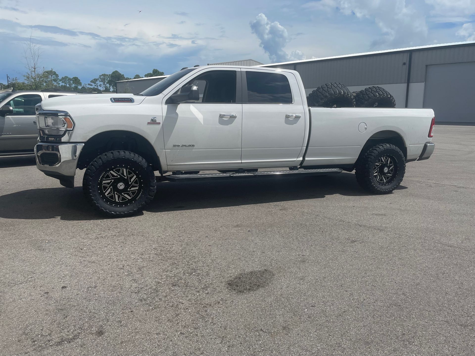 A white ram truck is parked in a parking lot.
