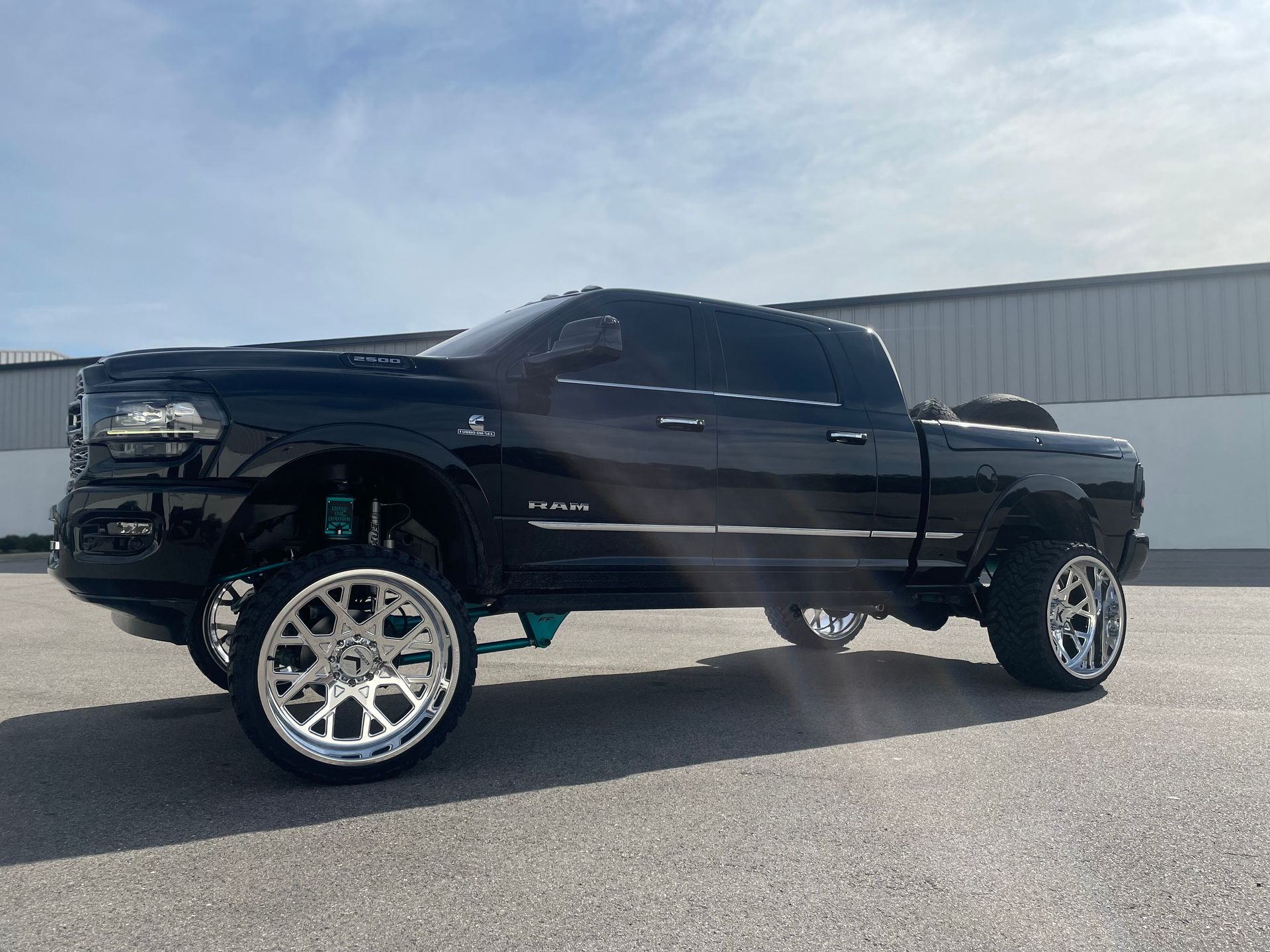 A black dodge ram truck is parked in front of a building.