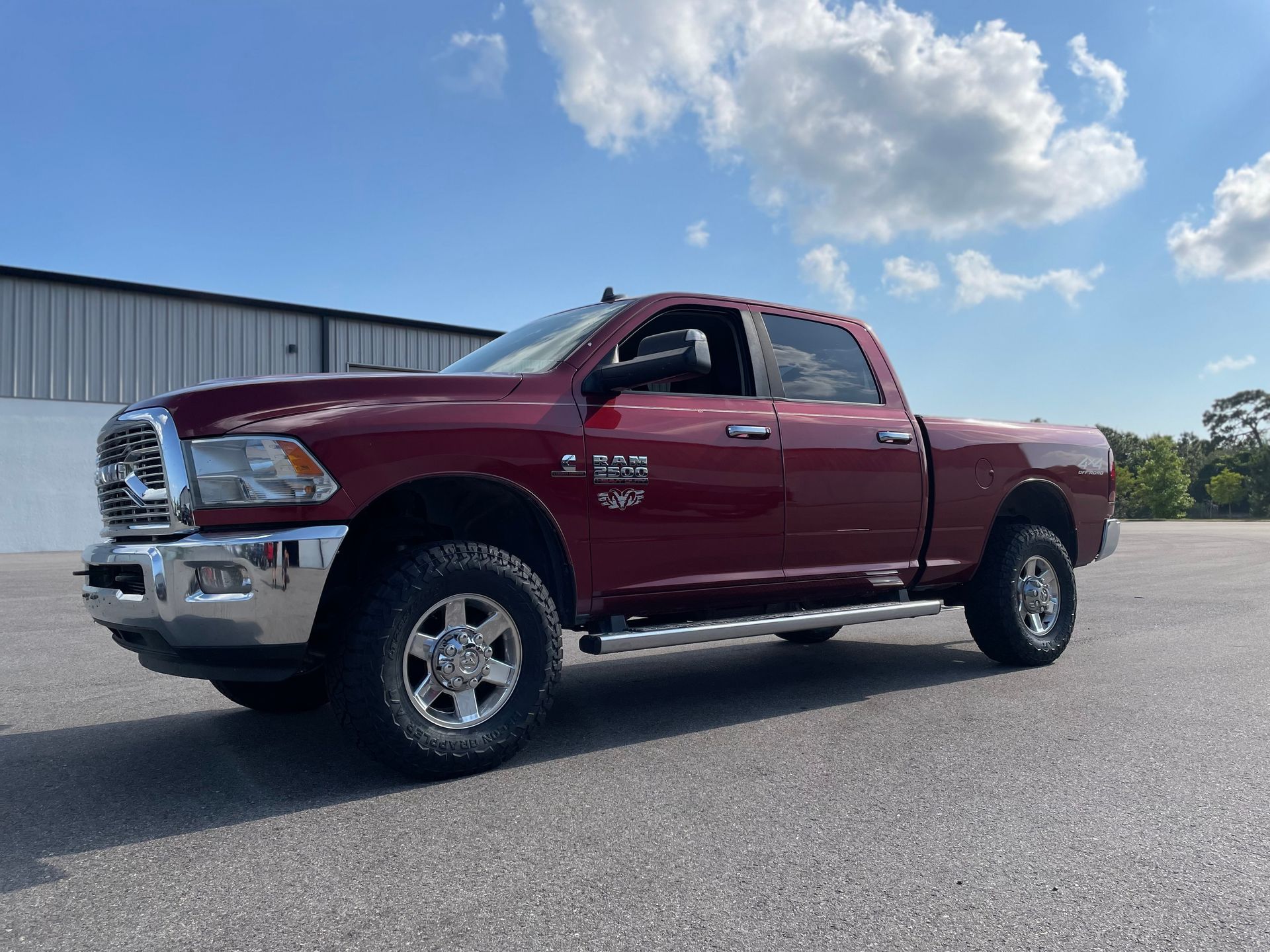 A red ram truck is parked in a parking lot.
