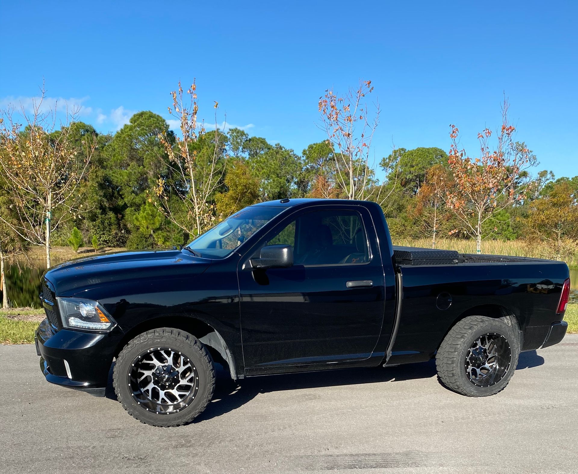 A black dodge ram truck is parked in a parking lot.