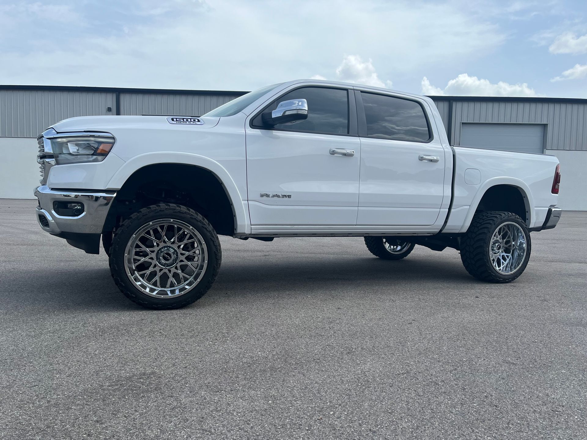 A white ram 1500 truck is parked in front of a building.