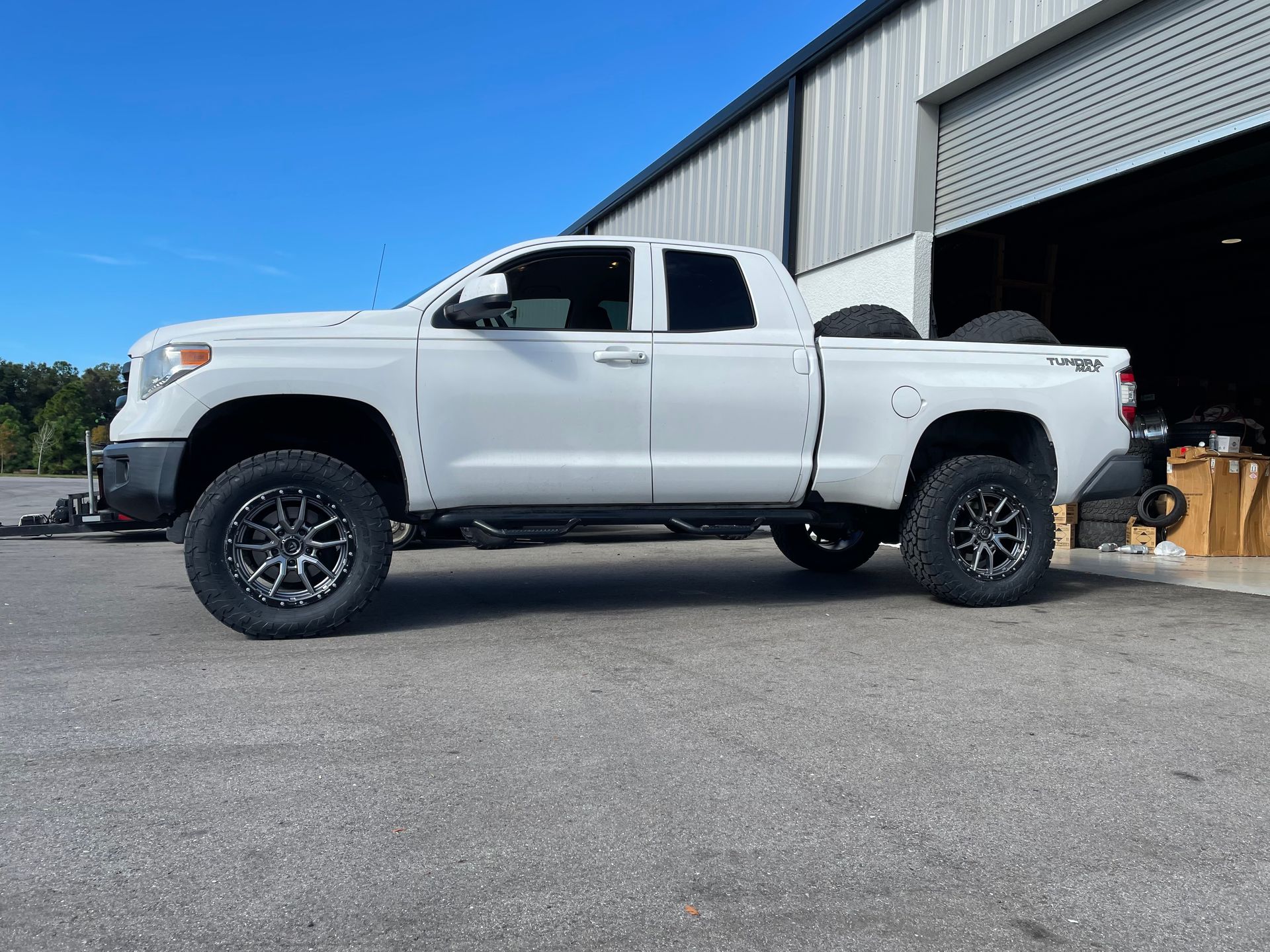 A white truck is parked in front of a building.