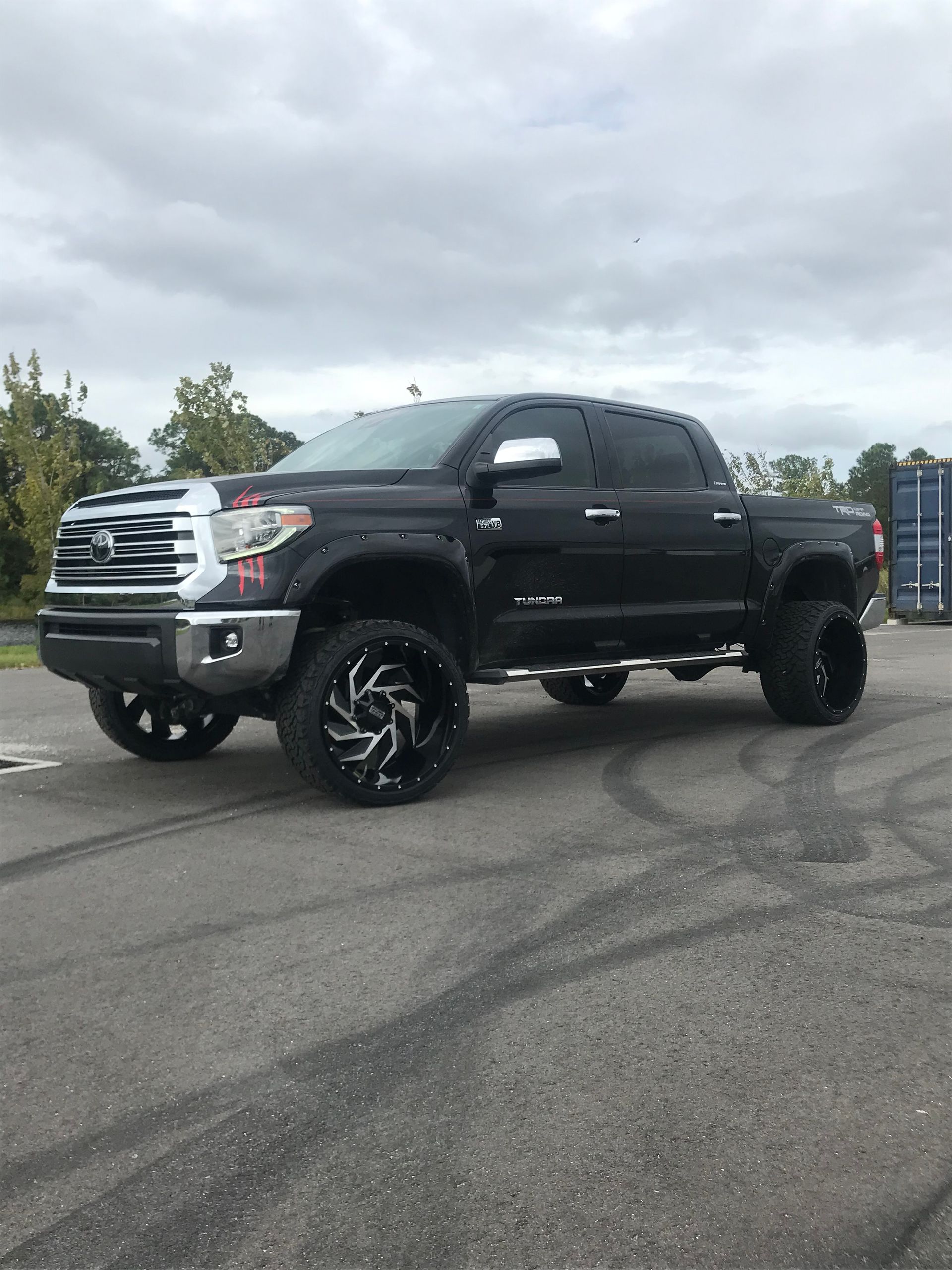 A black toyota tundra is parked on the side of the road.
