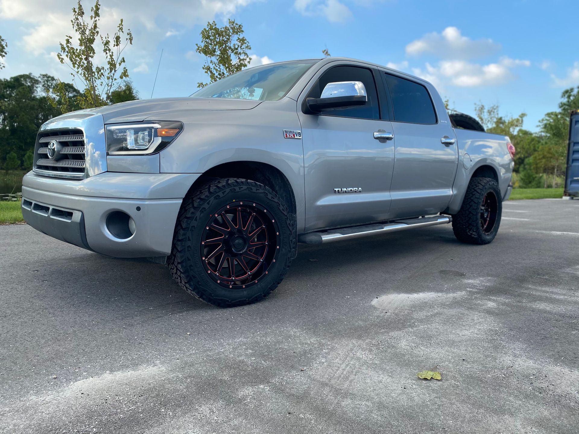 A silver toyota tundra is parked in a parking lot.