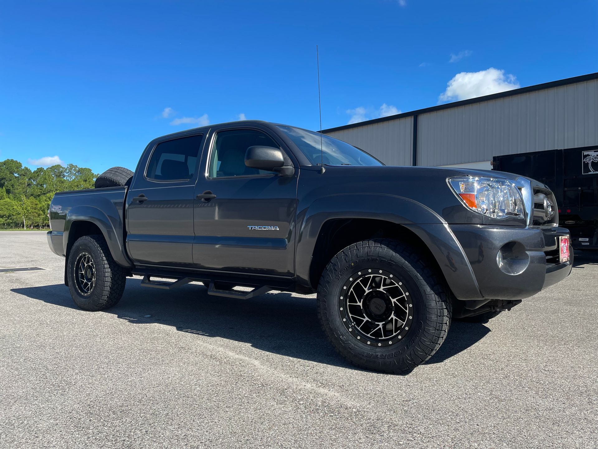 A toyota tacoma truck is parked in a parking lot in front of a building.