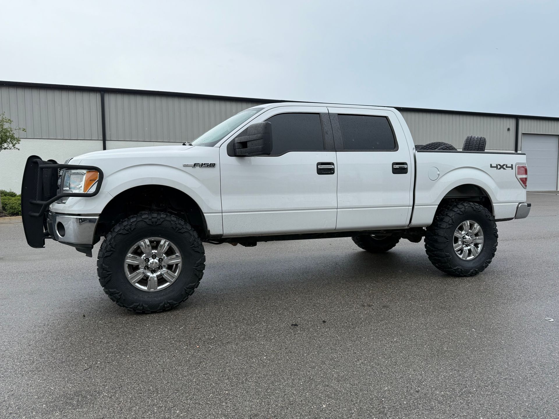 A white pickup truck is parked in front of a building.
