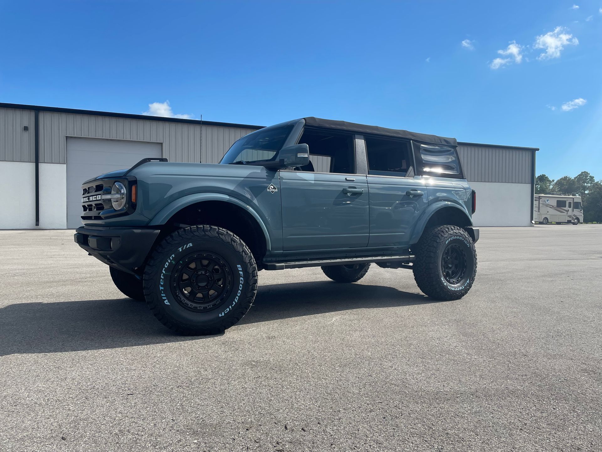 A ford bronco is parked in front of a building.