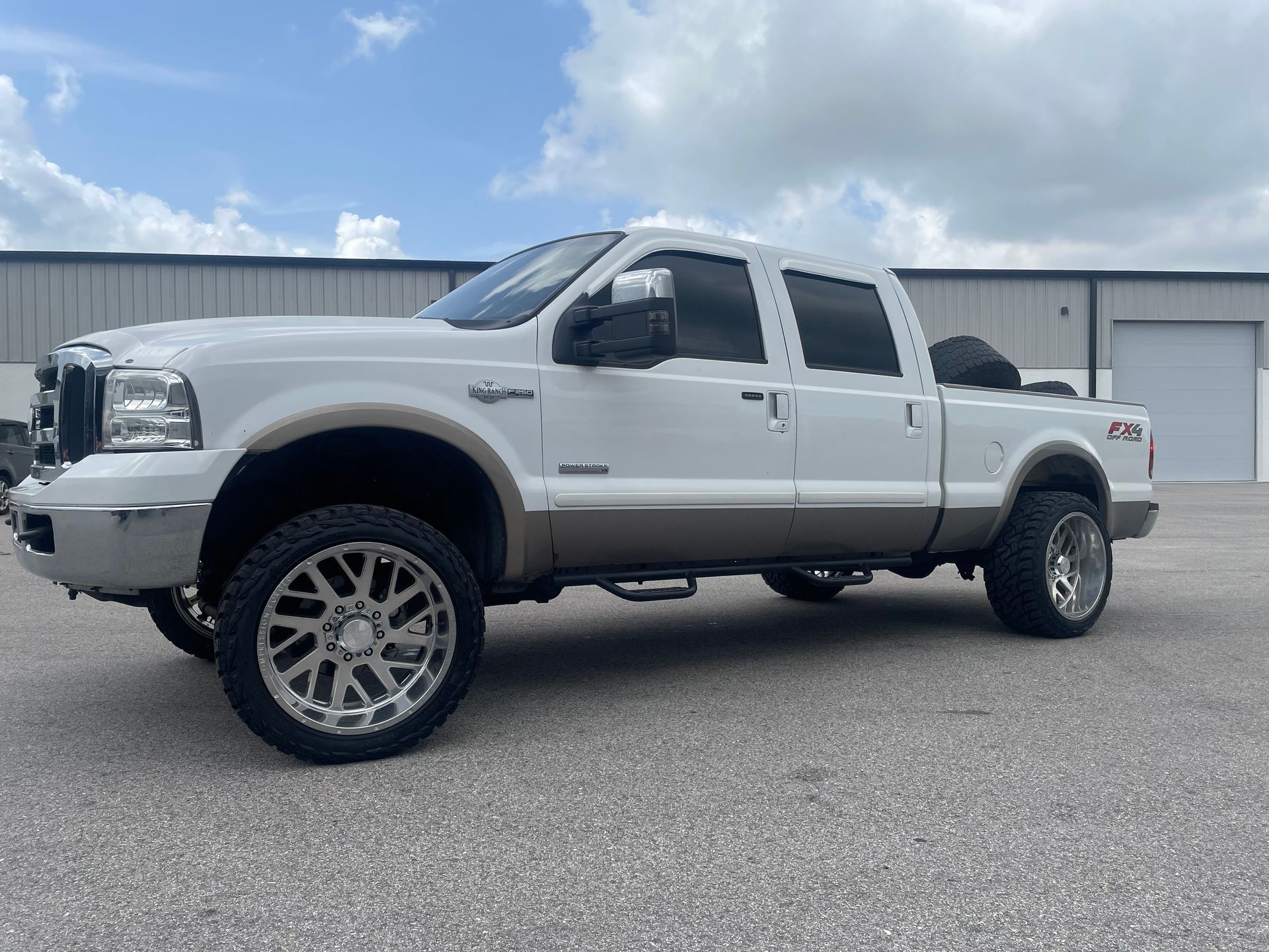 A white pickup truck is parked in front of a building.
