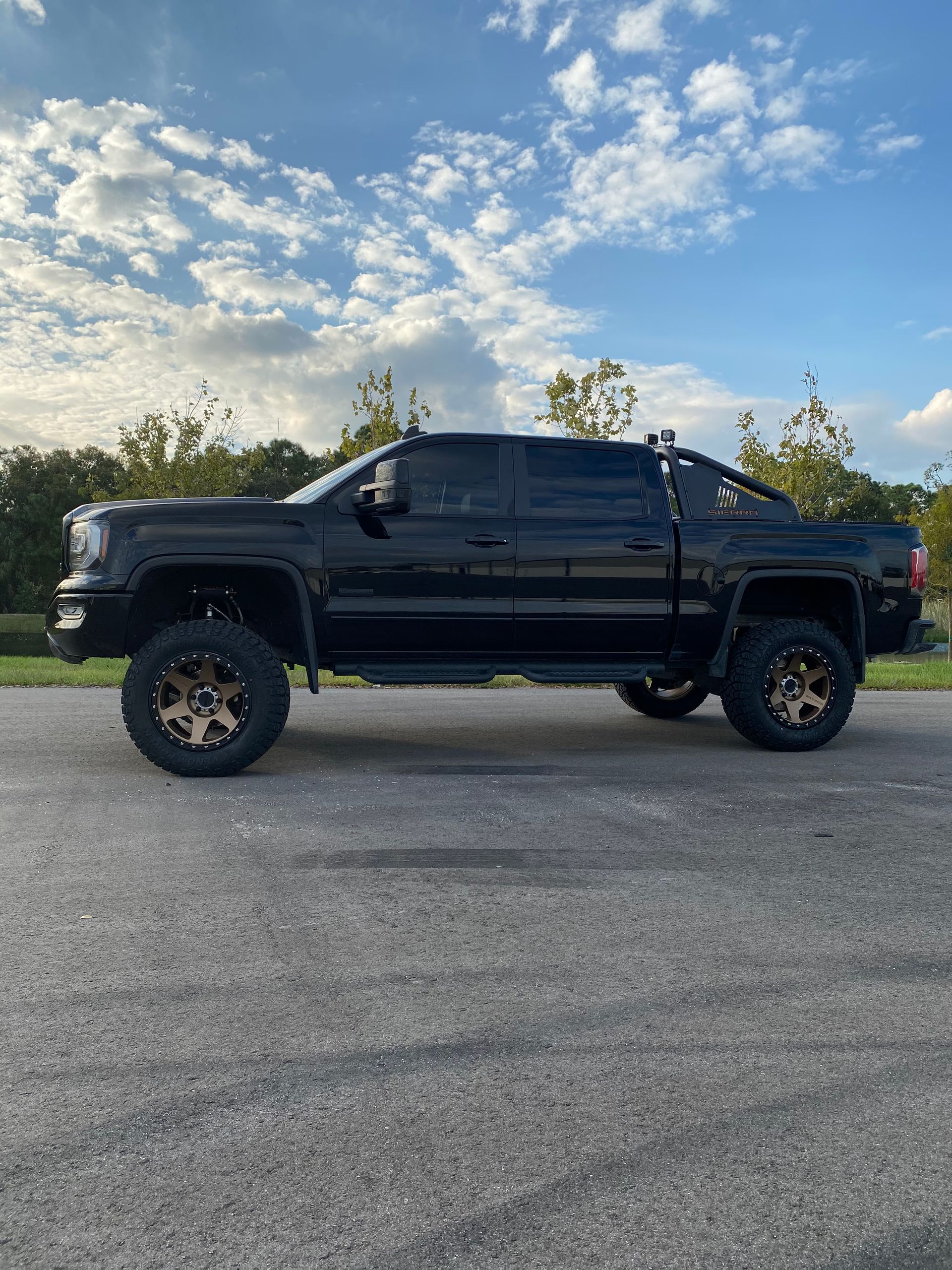 A black truck is parked on the side of the road.