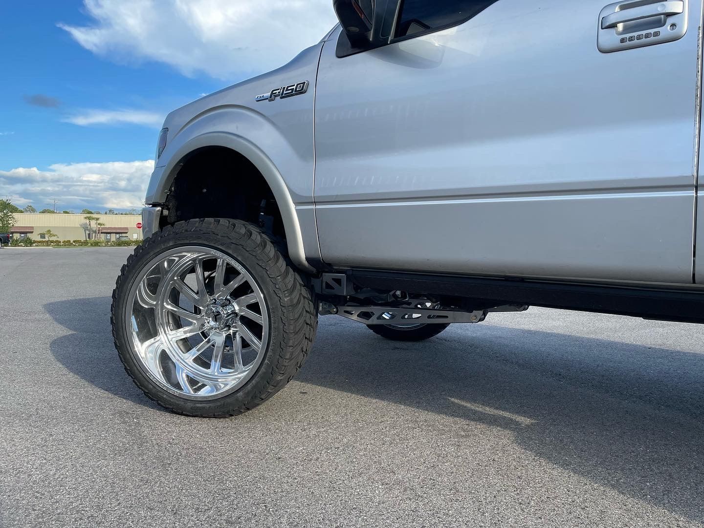 A silver truck is parked on the side of the road.