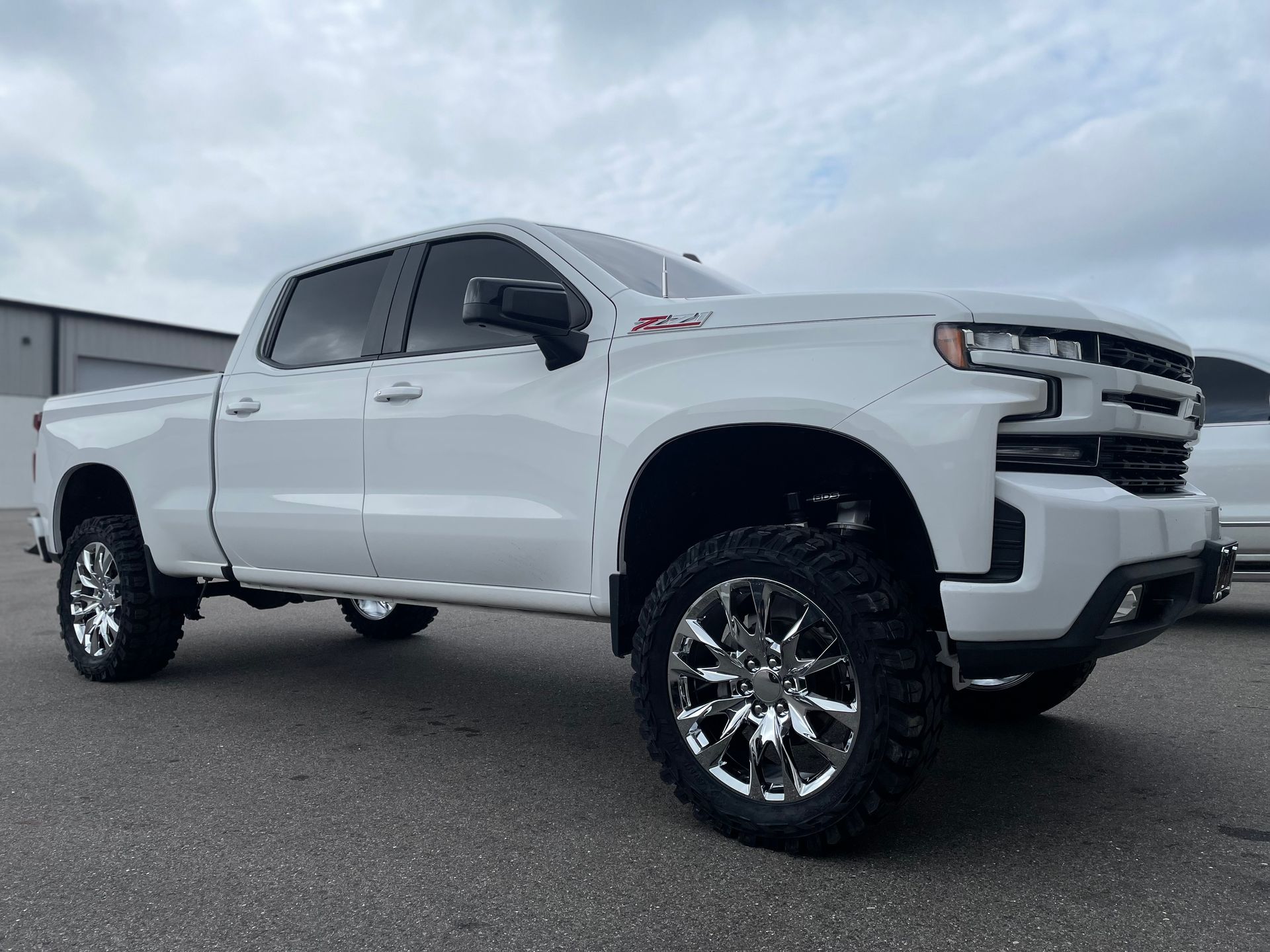 A white truck is parked on the side of the road.