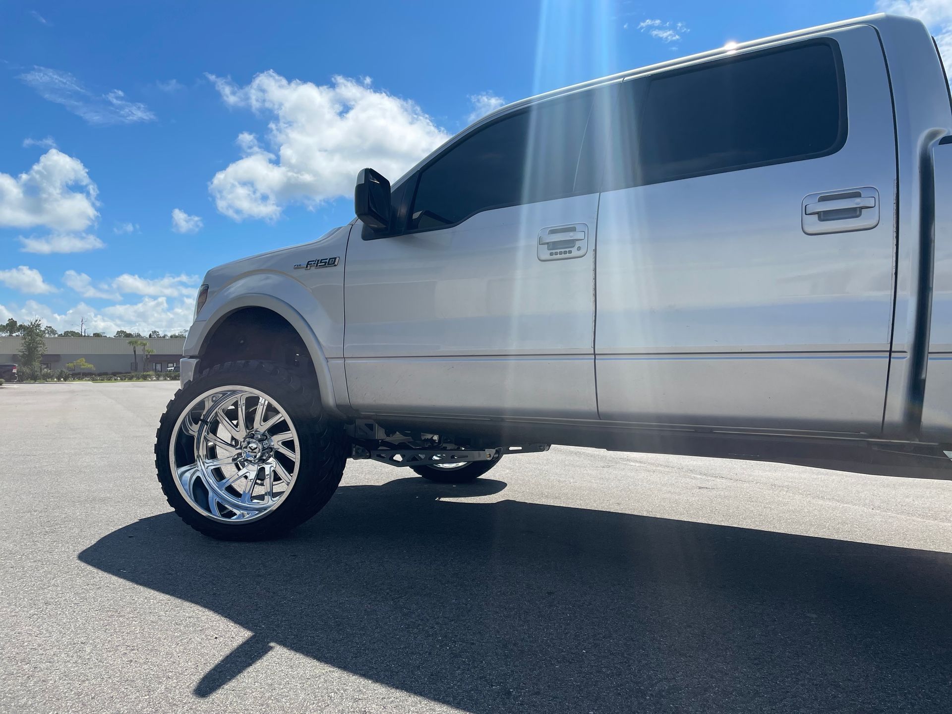 A silver pickup truck is parked on the side of the road.