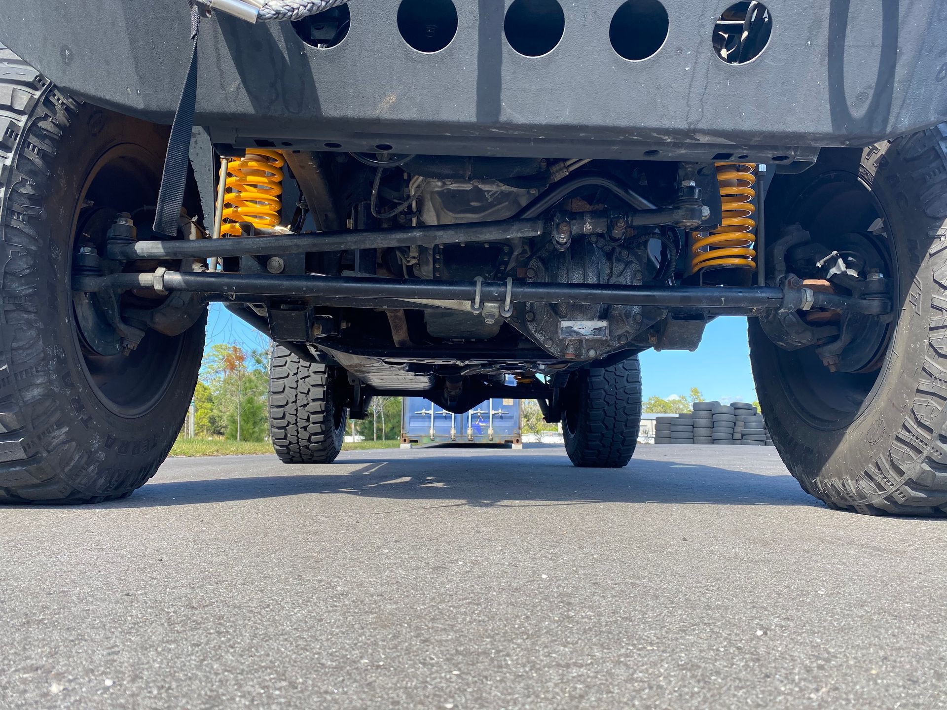 A close up of the underside of a jeep parked on the road.