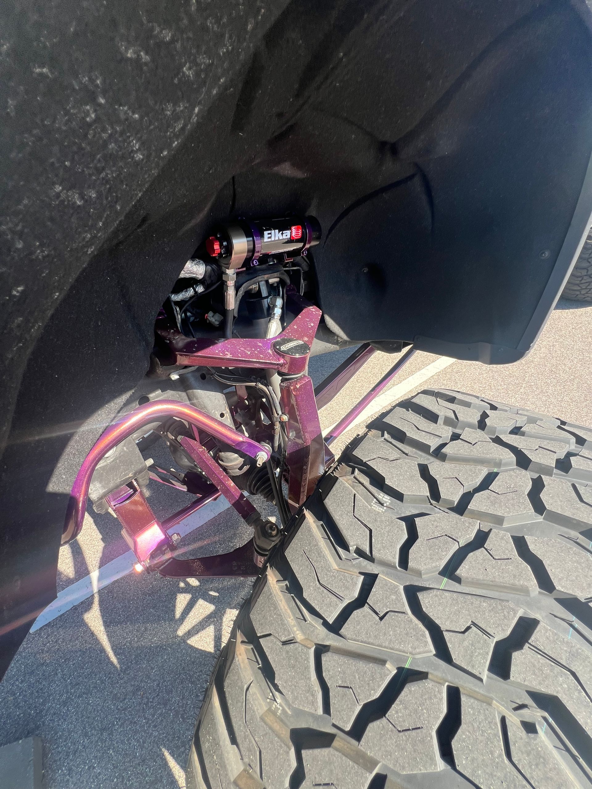A close up of a truck 's suspension and tires.