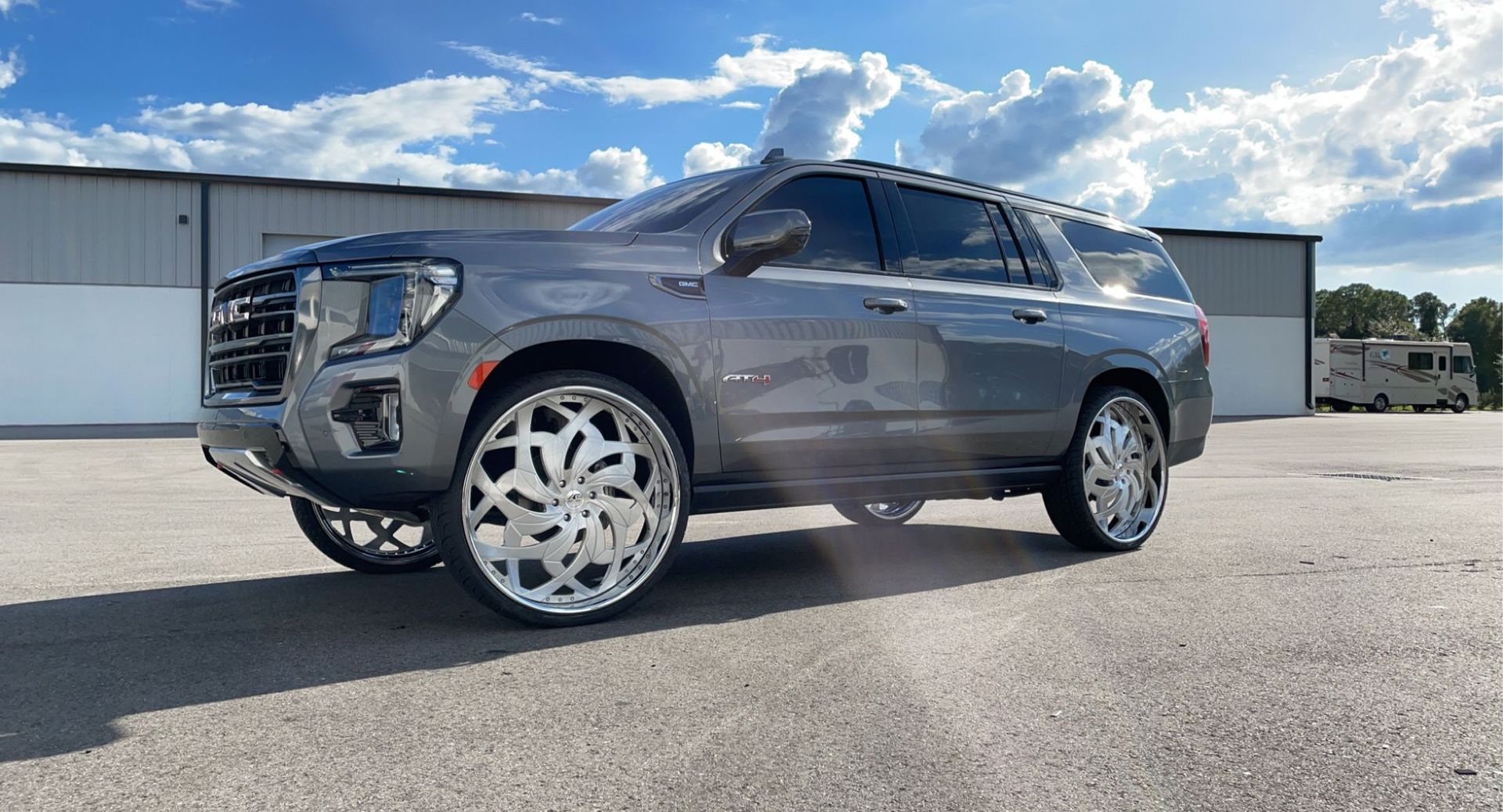 A gray suv is parked in a parking lot in front of a building.