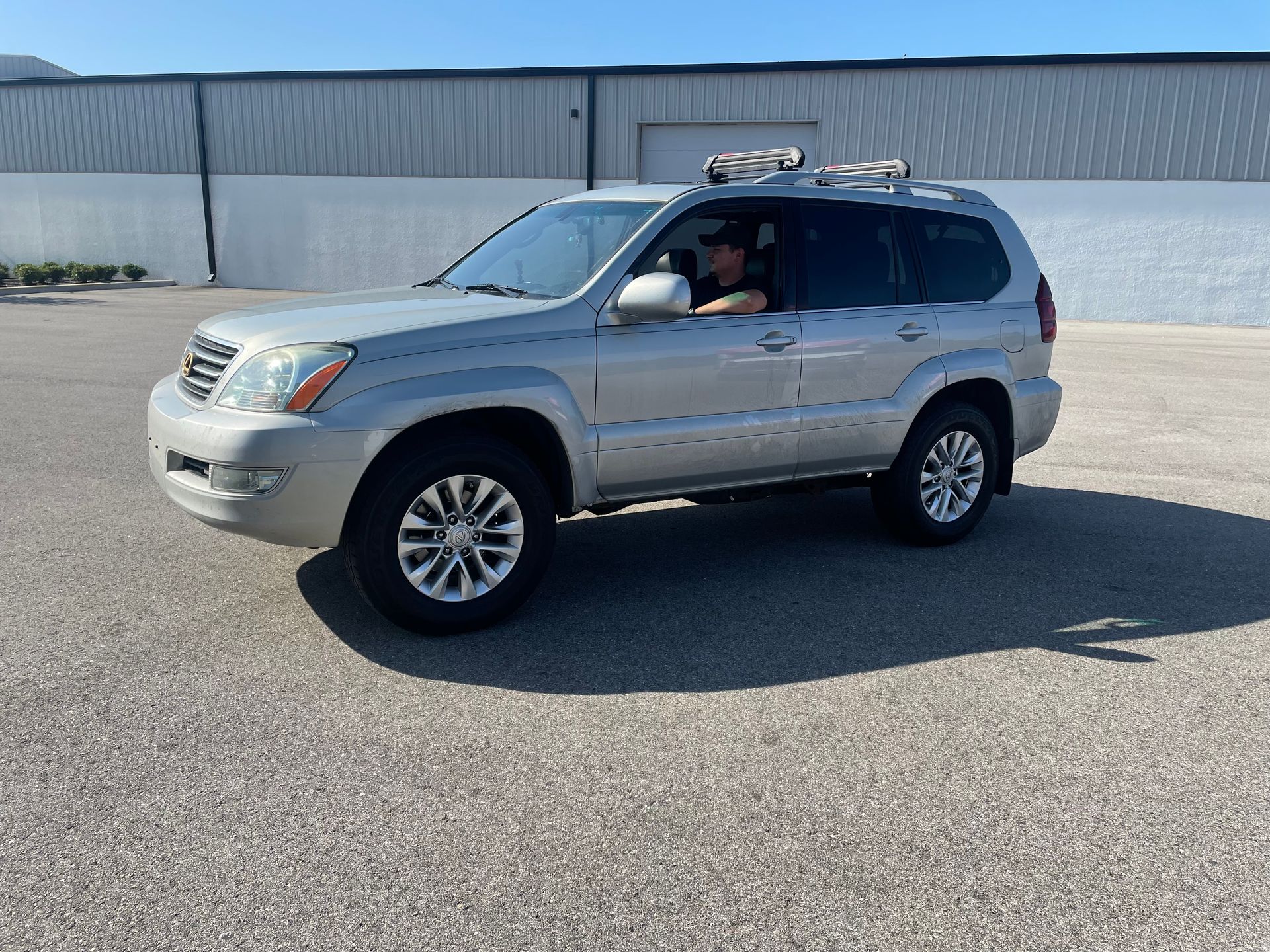 A white truck is parked in a parking lot in front of a building.