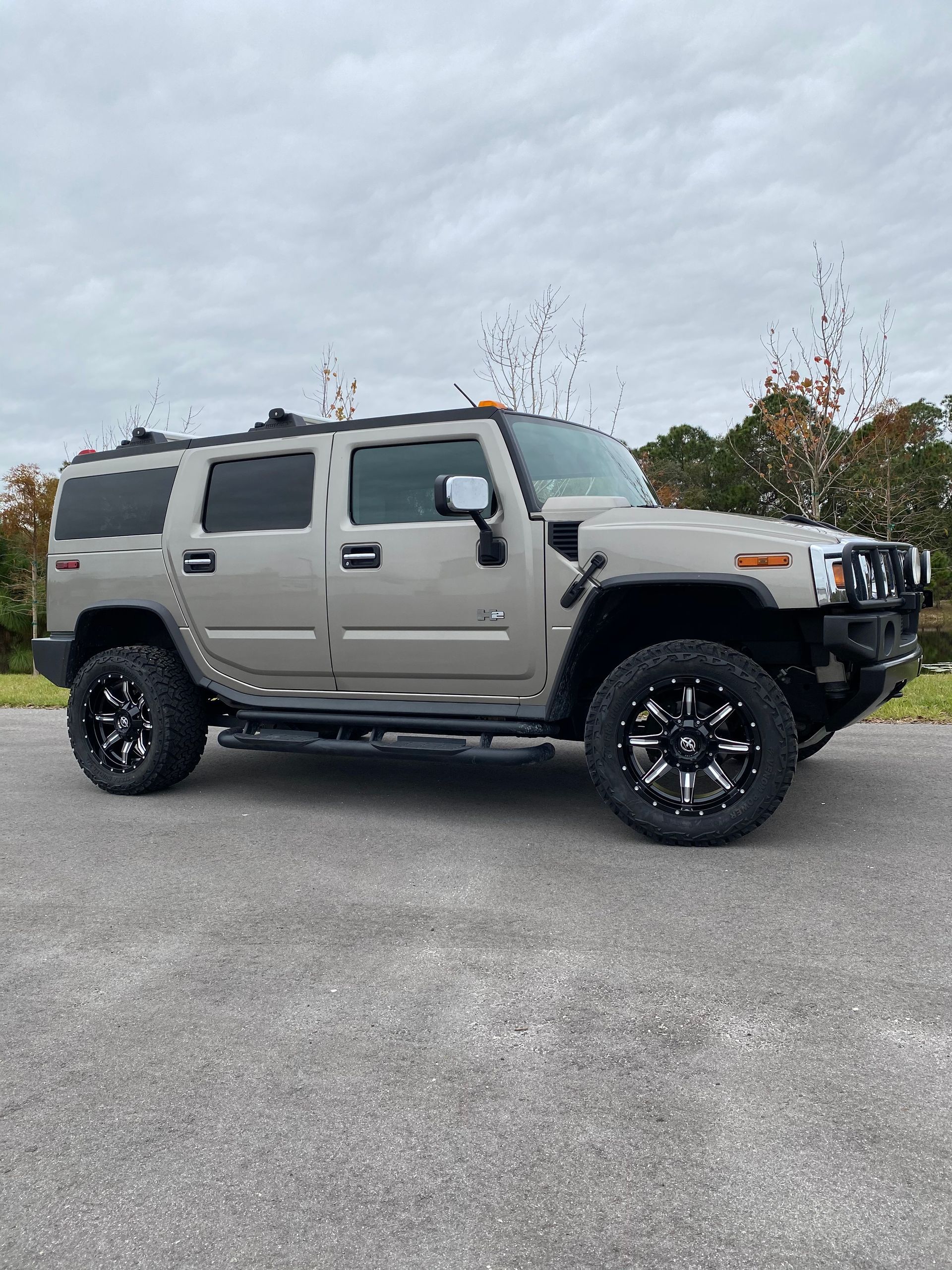 A hummer h2 is parked on the side of the road.