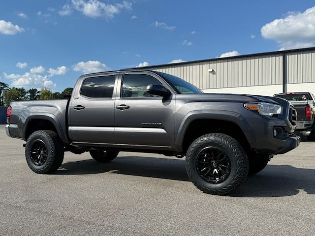 Gray Toyota Tacoma truck with black wheels parked outside on a sunny day.