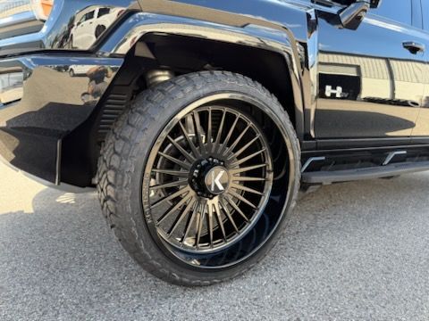 Black Hummer H3 SUV with black rims.