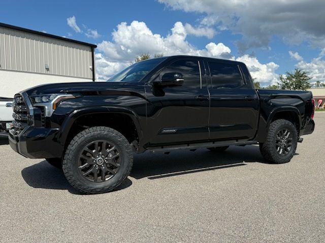 Black Toyota Tundra truck parked outside a building on a sunny day.