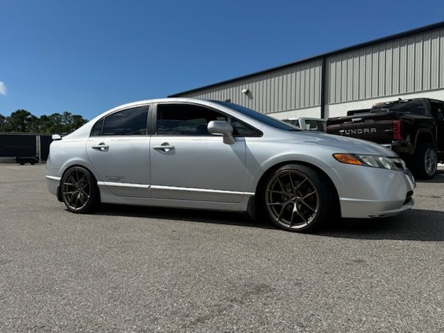 Silver Honda Civic sedan with custom bronze wheels lowered on asphalt.