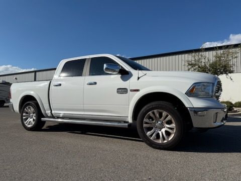 White Ram pickup truck parked on asphalt in front of a building on a sunny day.