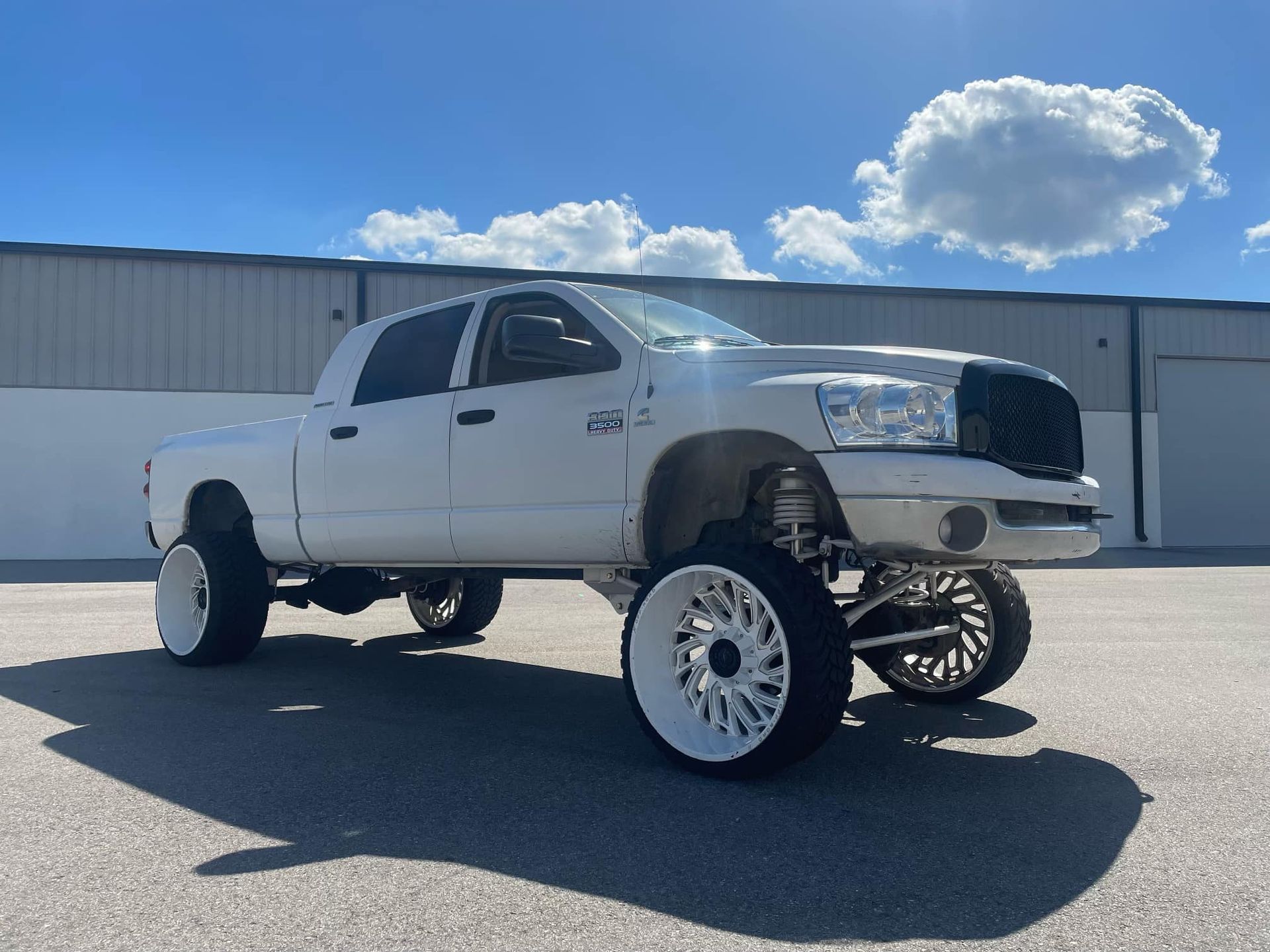 A white truck is parked in front of a building.