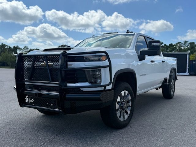 White pickup truck with black grille guard and side mirrors, parked outdoors on a sunny day.