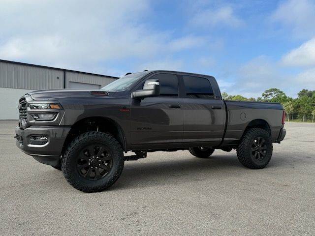 Dark gray Ram pickup truck with black wheels, parked outdoors.