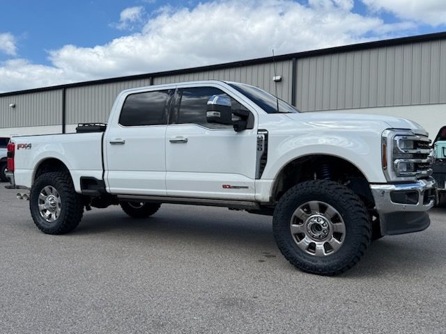 White Ford pickup truck parked in front of a building with a cloudy sky.