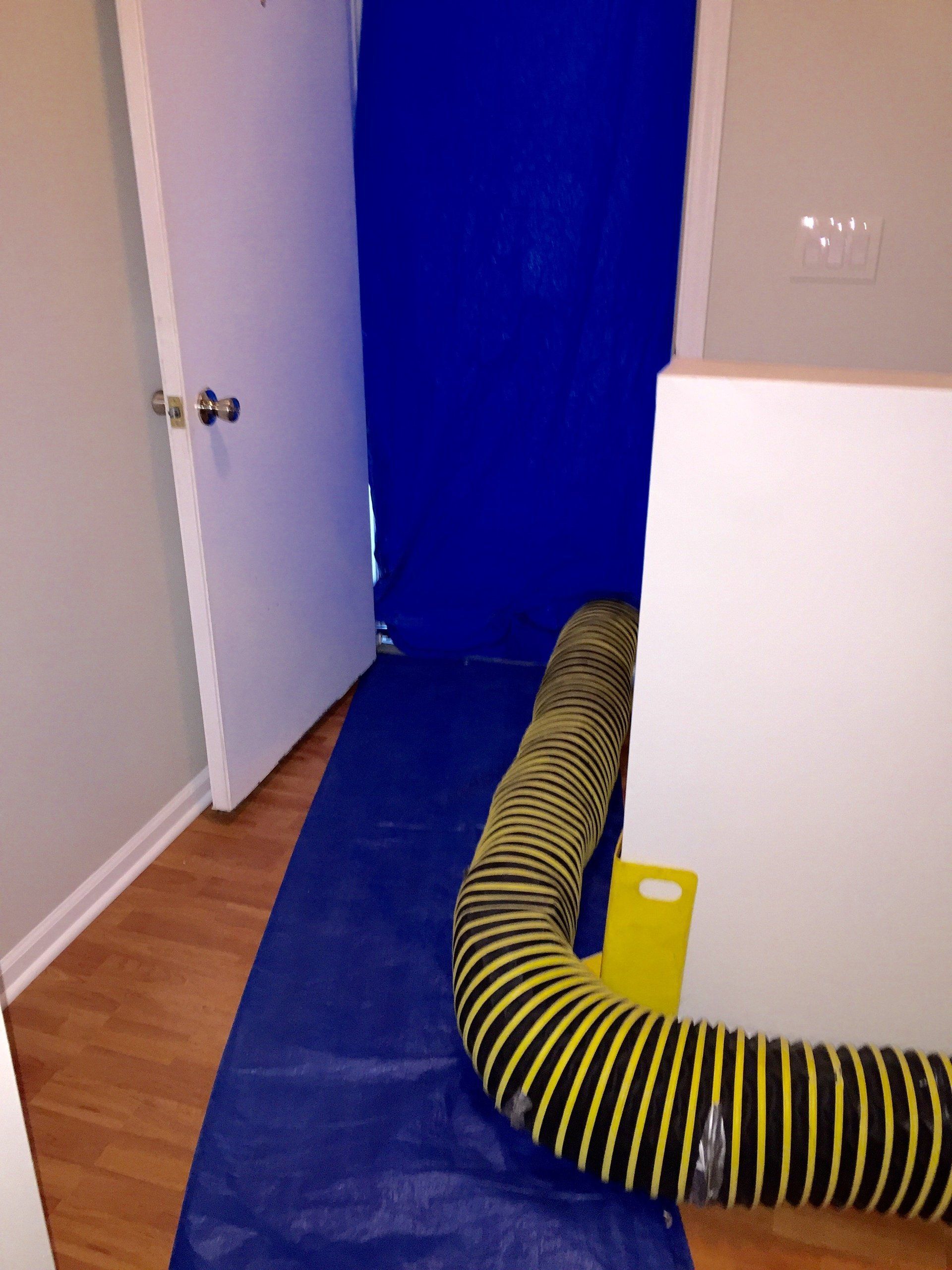 A blue door with a yellow hose attached to it