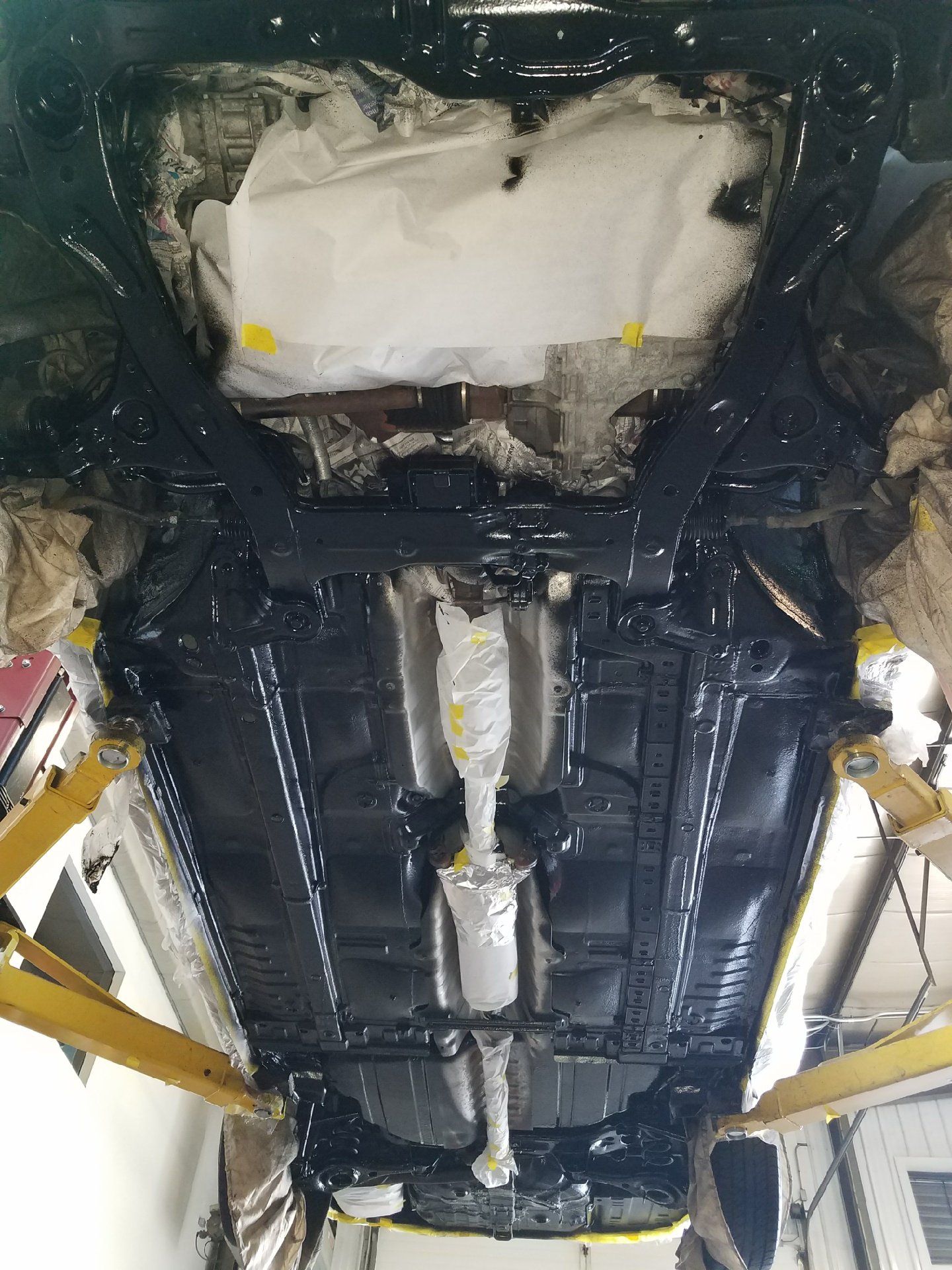 The underside of a car is covered in black paint.