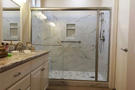 A bathroom with a walk in shower and a sink.