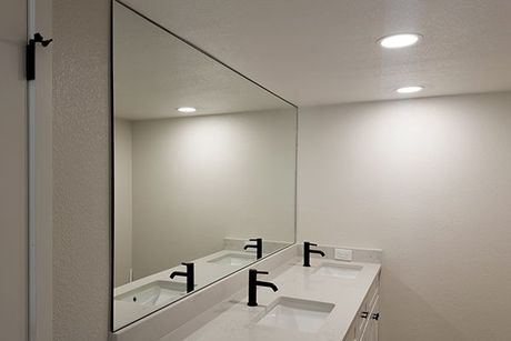 A bathroom with two sinks and a large mirror.